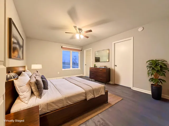 a spacious bedroom with a bed and ceiling fan