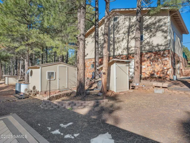 a view of a white house with a large tree