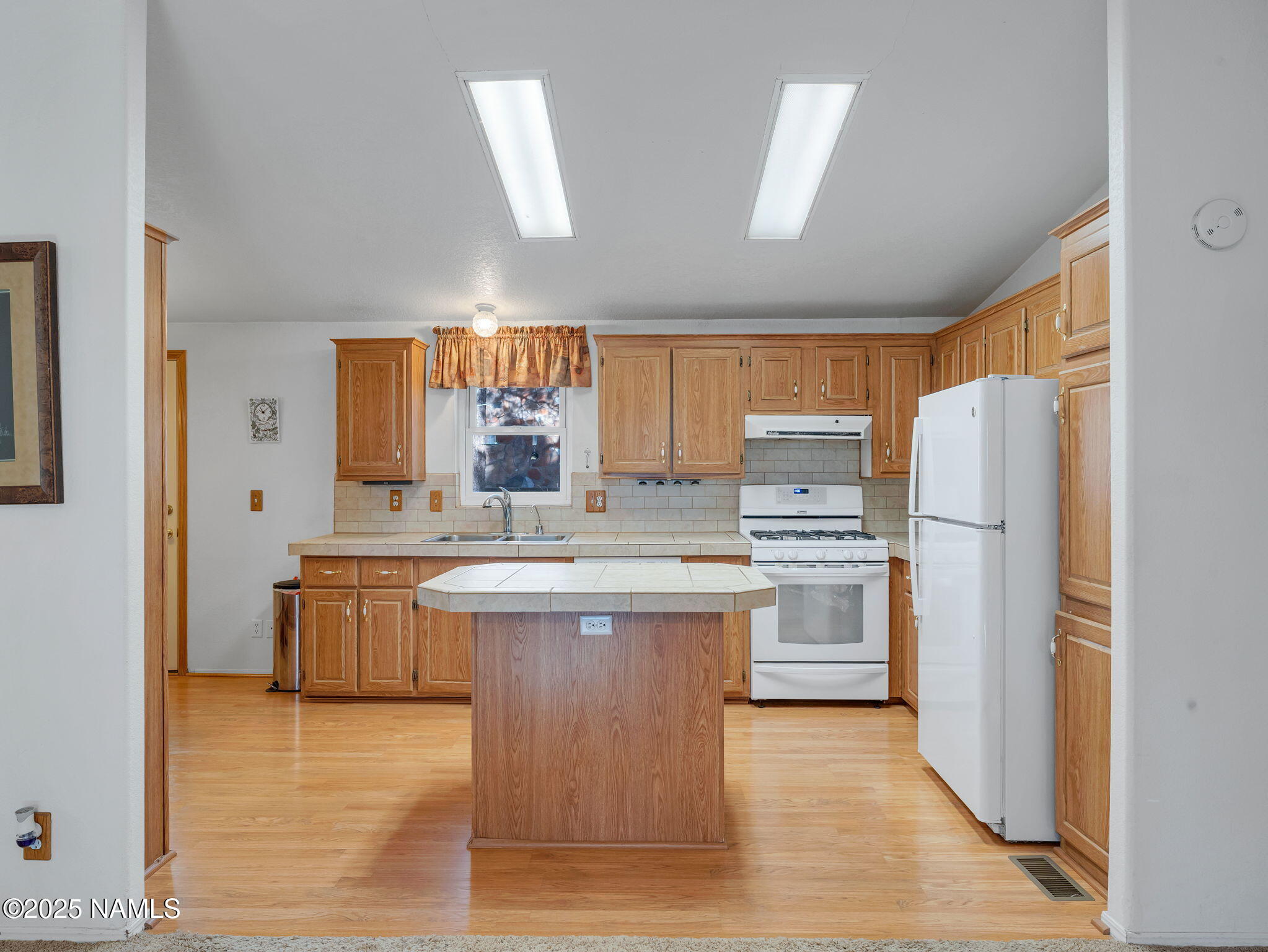 13112 Fallow Deer Road Parks, AZ 86018 - Photo 8 of 39 a kitchen with stainless steel appliances granite countertop a refrigerator a sink dishwasher a stove with wooden cabinets and wooden floor