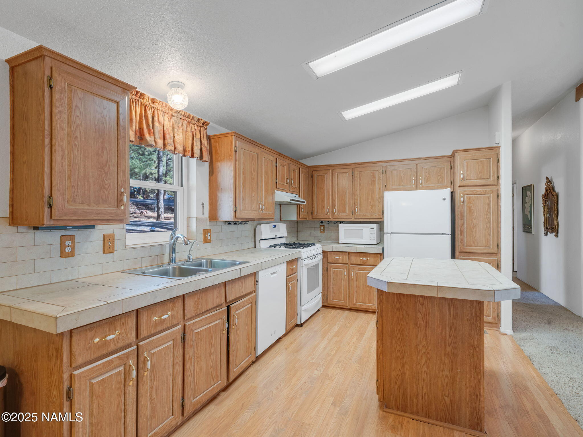 13112 Fallow Deer Road Parks, AZ 86018 - Photo 9 of 39 a kitchen with a sink refrigerator and cabinets