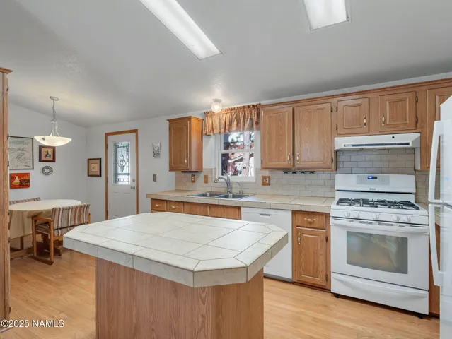 a kitchen with a stove sink and cabinets