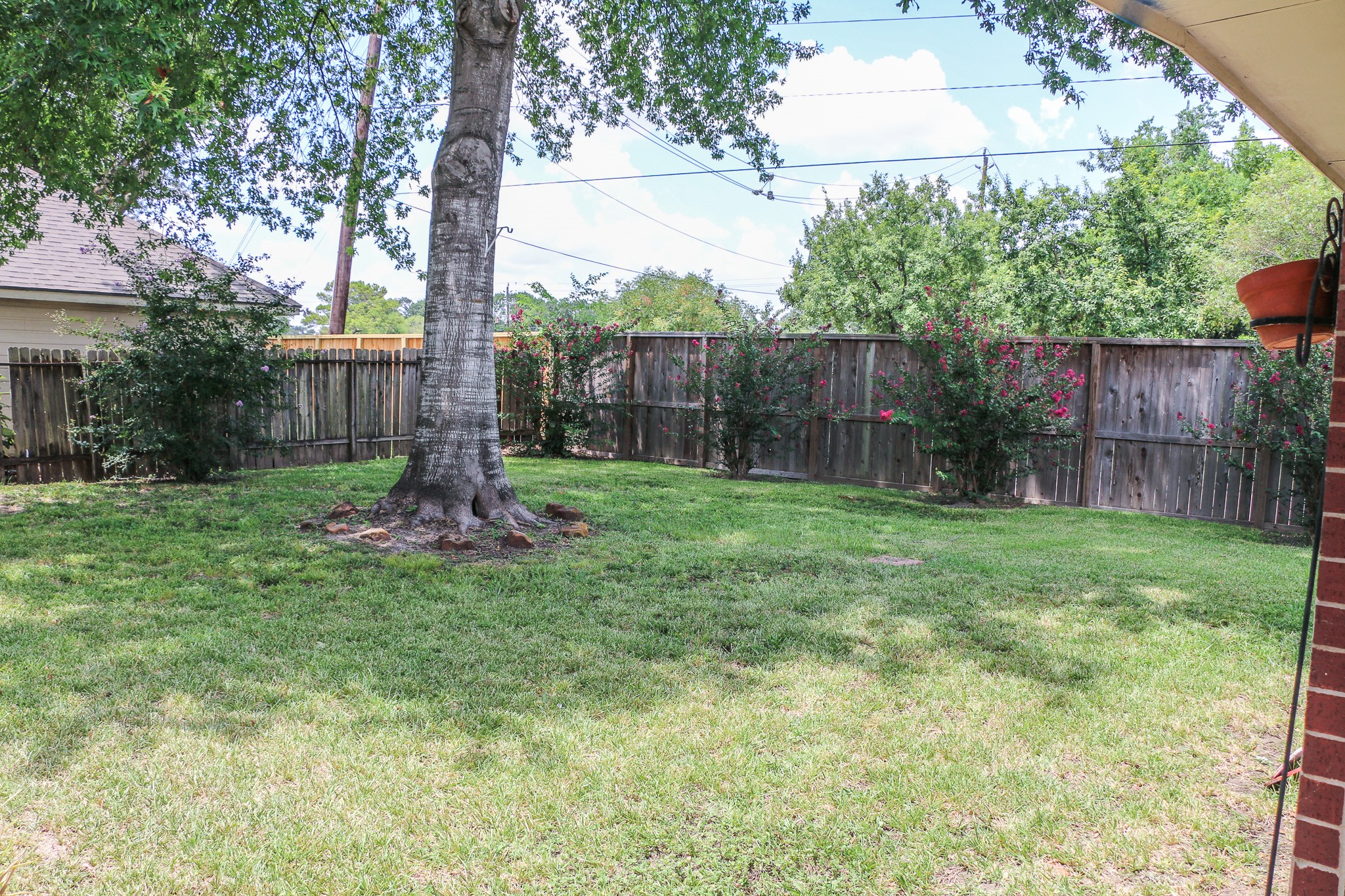 3306 Elmcrest Drive Houston, TX 77088 - Photo 19 of 19 a view of a backyard with a tree and wooden fence