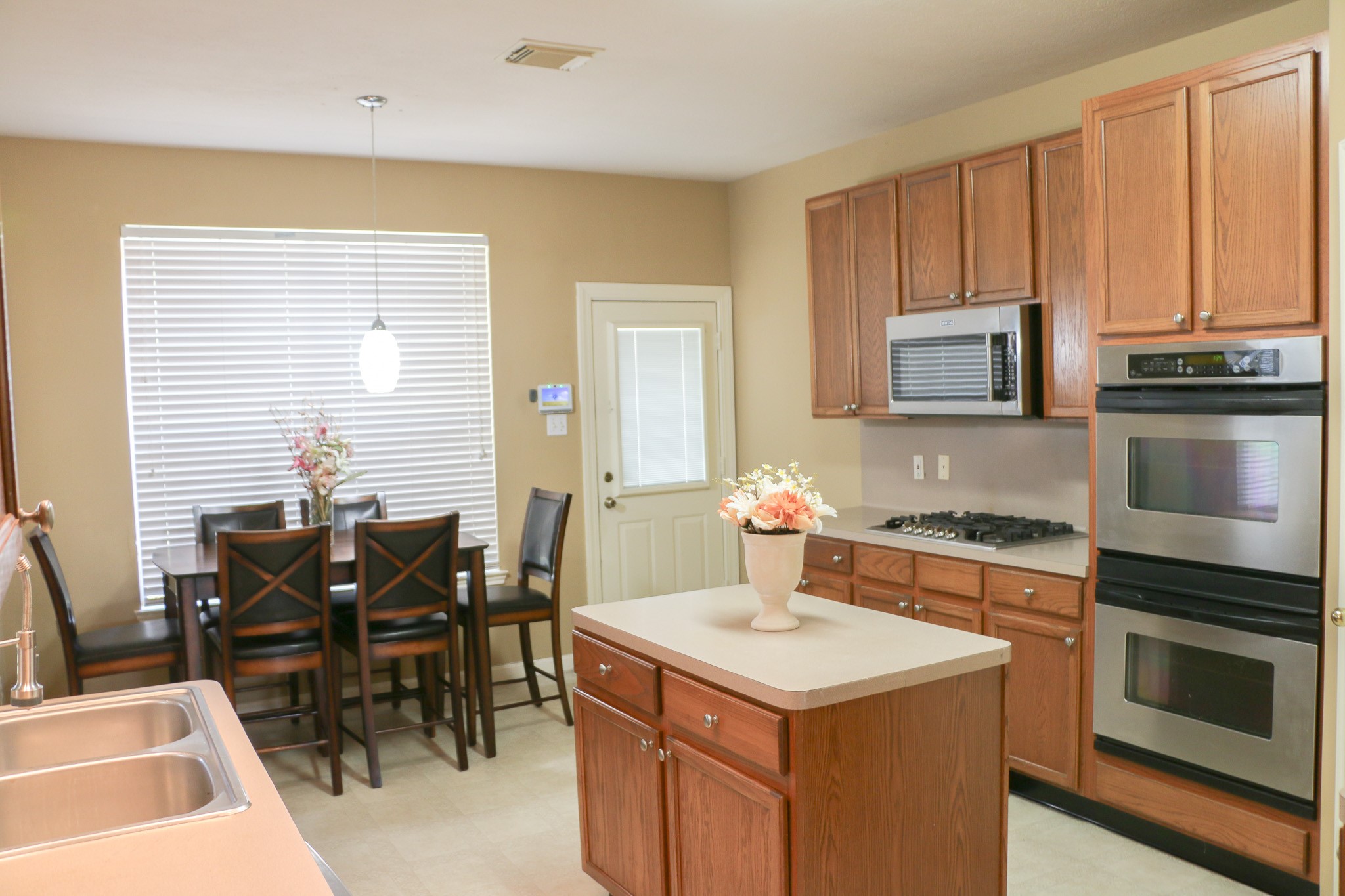 3306 Elmcrest Drive Houston, TX 77088 - Photo 10 of 19 a kitchen with a stove a sink a microwave and dining table