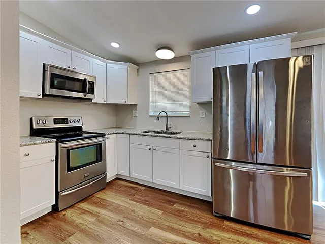 a kitchen with stainless steel appliances a refrigerator sink and microwave
