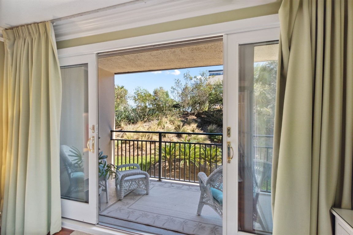 1163 Beach Walker Road, Unit 1163 Fernandina Beach, FL 32034 - Photo 24 of 58 a view of a balcony with chair and the potted plant next to a window
