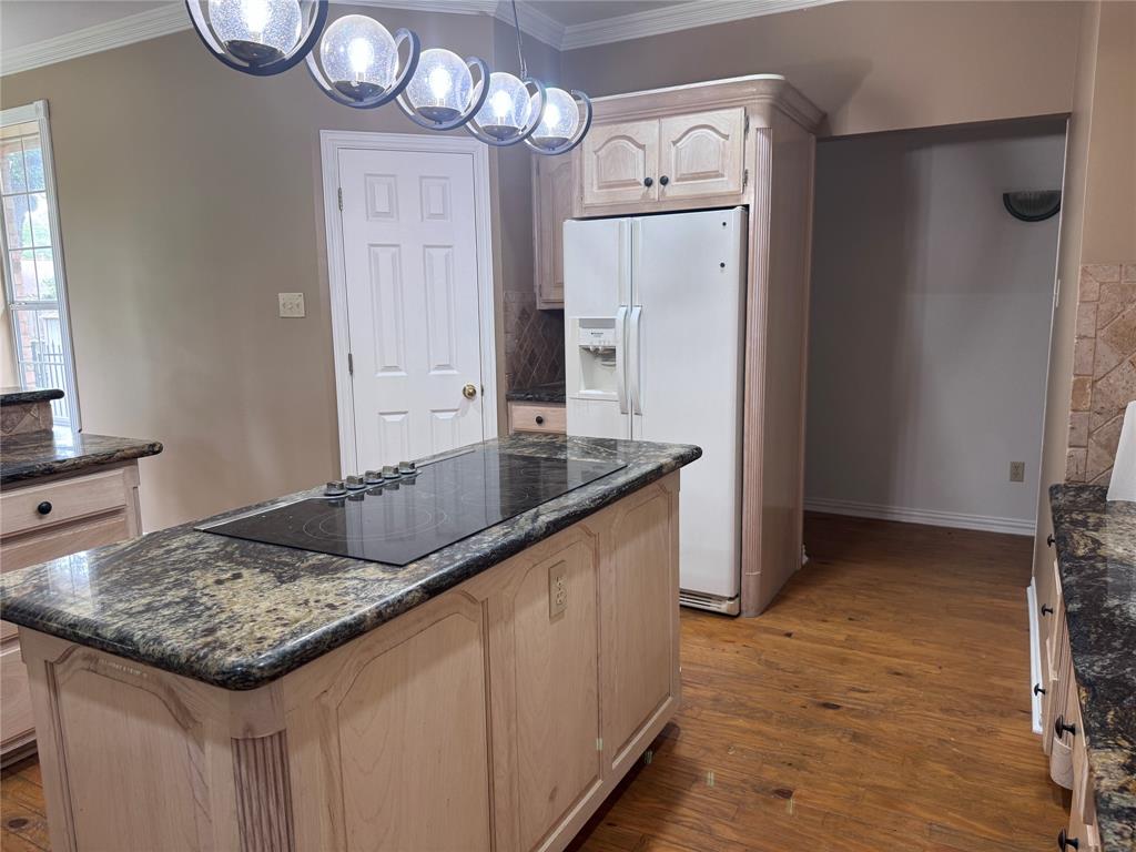 1704 South Bowen Road Pantego, TX 76013 - Photo 12 of 37 Kitchen featuring a central island with an integrated cooktop and granite countertop