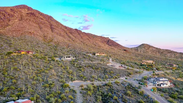 a view of a dry yard with mountains in the background