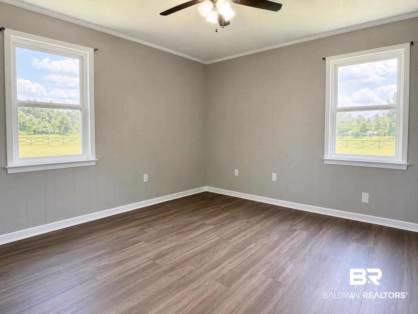 11115 Appleton Road Castleberry, AL 36432 - Photo 8 of 18 Room featuring warm wood-finish flooring, light gray walls with wainscoting, and white trim