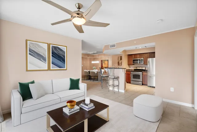 a living room with furniture a rug and a ceiling fan