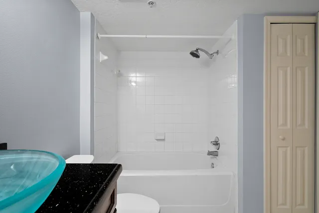 a bathroom with a granite countertop sink toilet and shower