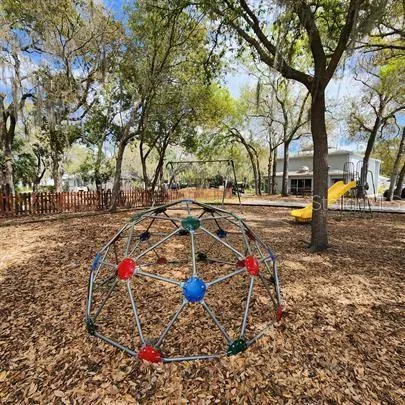 a view of a house with large tree and wooden fence
