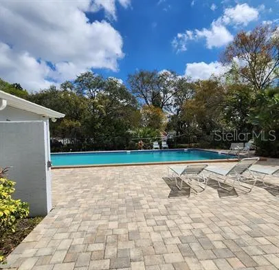 a backyard of a house with table and chairs under an umbrella