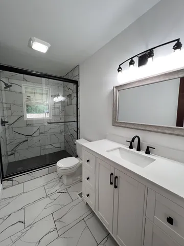 a bathroom with a sink a toilet and shower