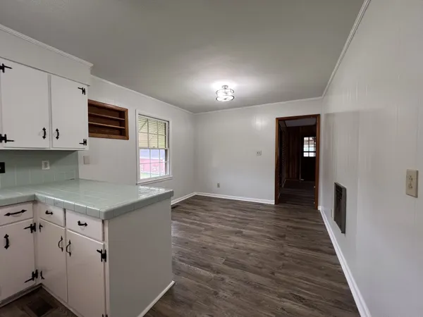 an empty room with wooden floor and window