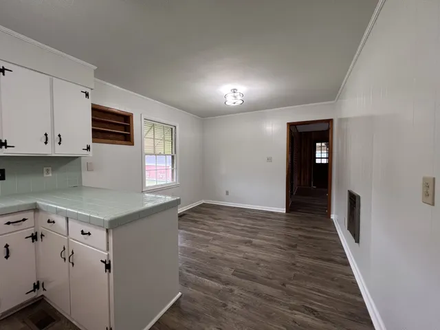 an empty room with wooden floor and window