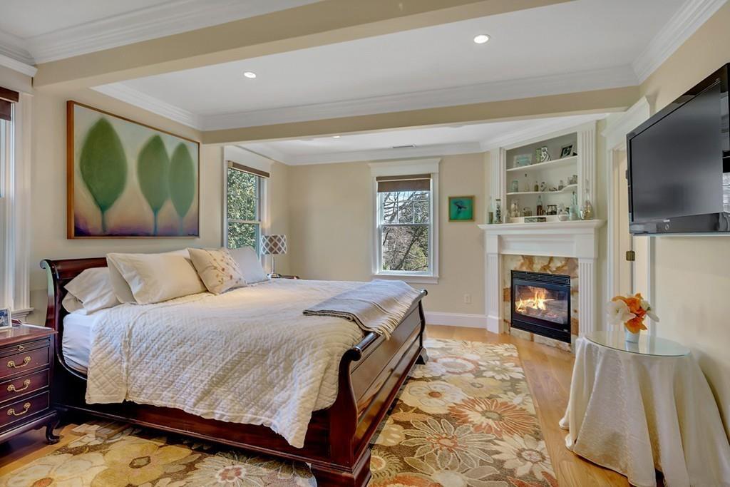 33 Everett Street Concord, MA 01742 - Photo 19 of 42 a spacious bedroom with a bed and a fireplace