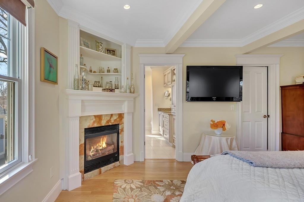 33 Everett Street Concord, MA 01742 - Photo 20 of 42 a bedroom with a flat screen tv and a fireplace