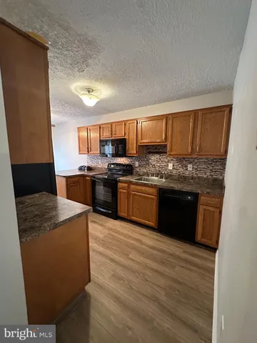 a kitchen with stainless steel appliances granite countertop a stove a sink dishwasher and a refrigerator