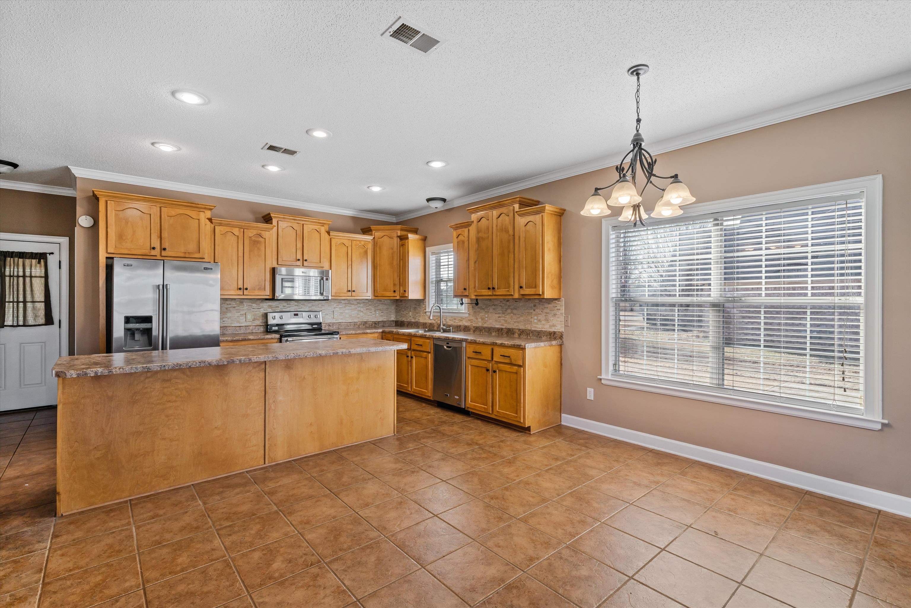 4972 Pleasant Ridge Drive Olive Branch, MS 38654 - Photo 11 of 24 a large kitchen with kitchen island granite countertop a stove and a chandelier