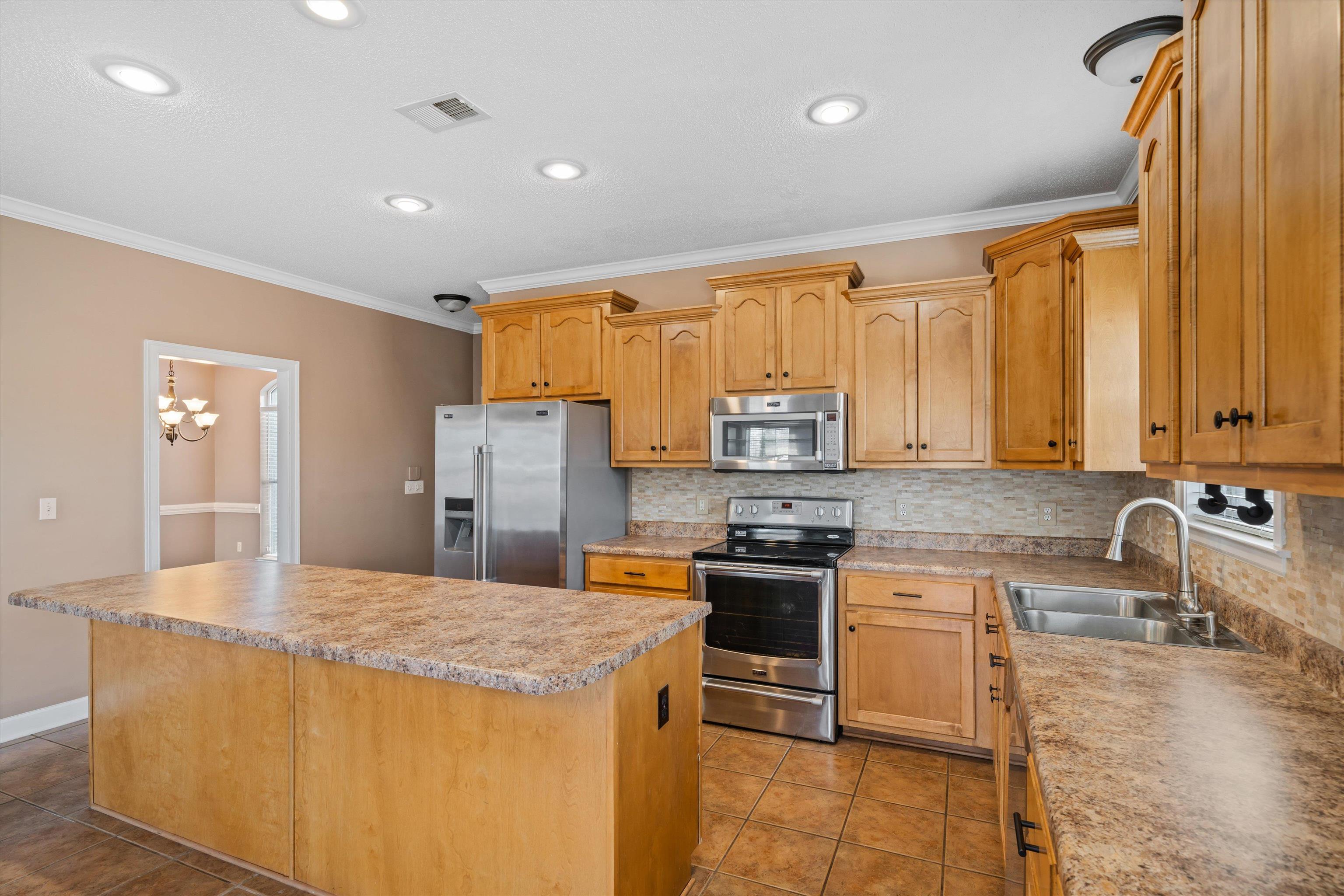 4972 Pleasant Ridge Drive Olive Branch, MS 38654 - Photo 13 of 24 a kitchen with stainless steel appliances granite countertop a sink stove and refrigerator