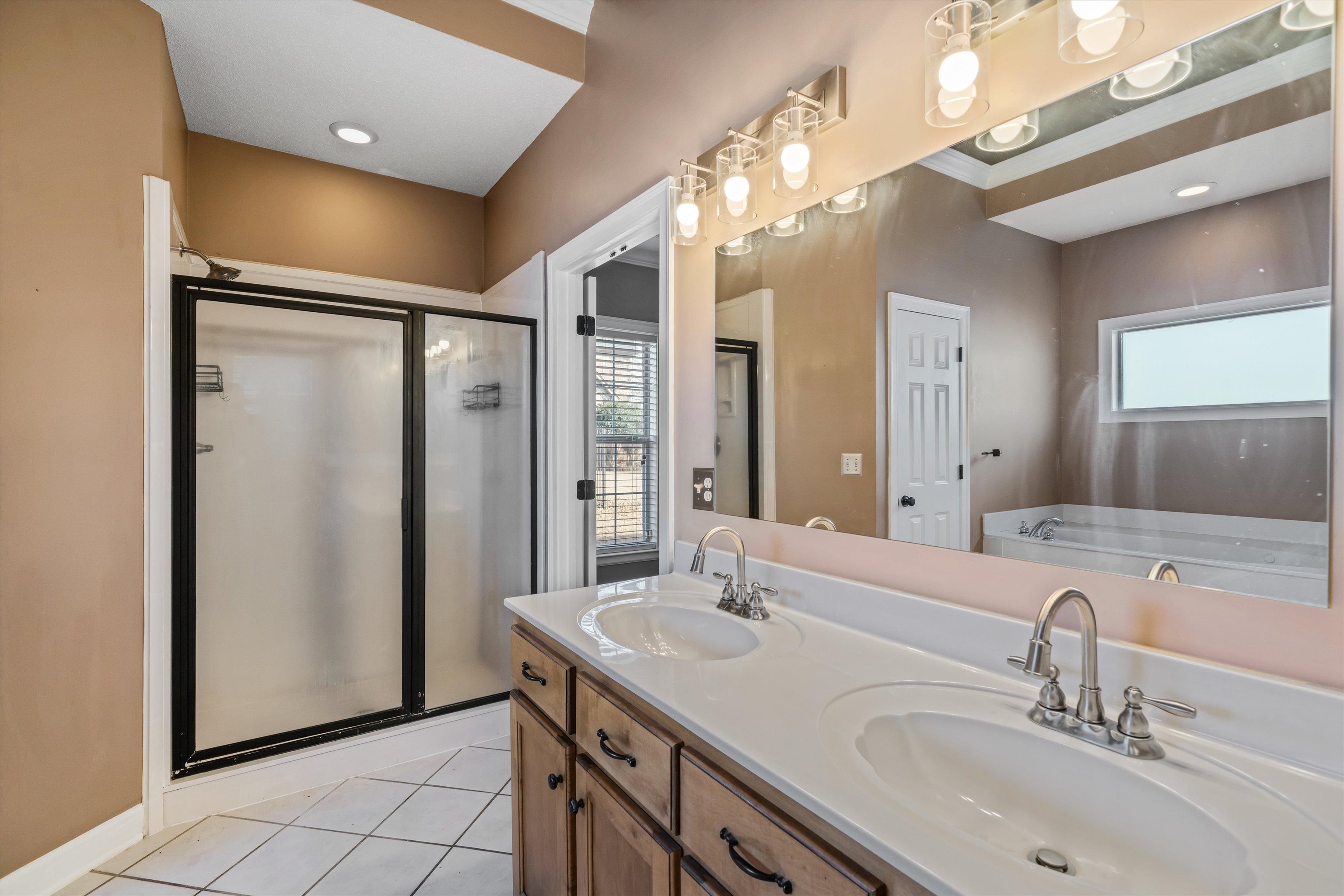 4972 Pleasant Ridge Drive Olive Branch, MS 38654 - Photo 18 of 24 a bathroom with a double vanity sink a mirror and a shower