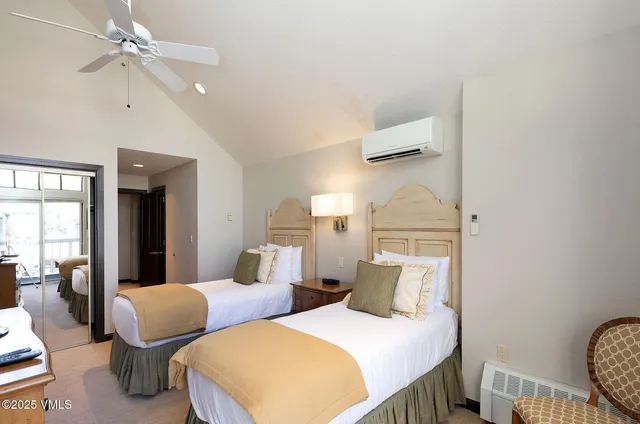 a bedroom with two beds and painting on the wall