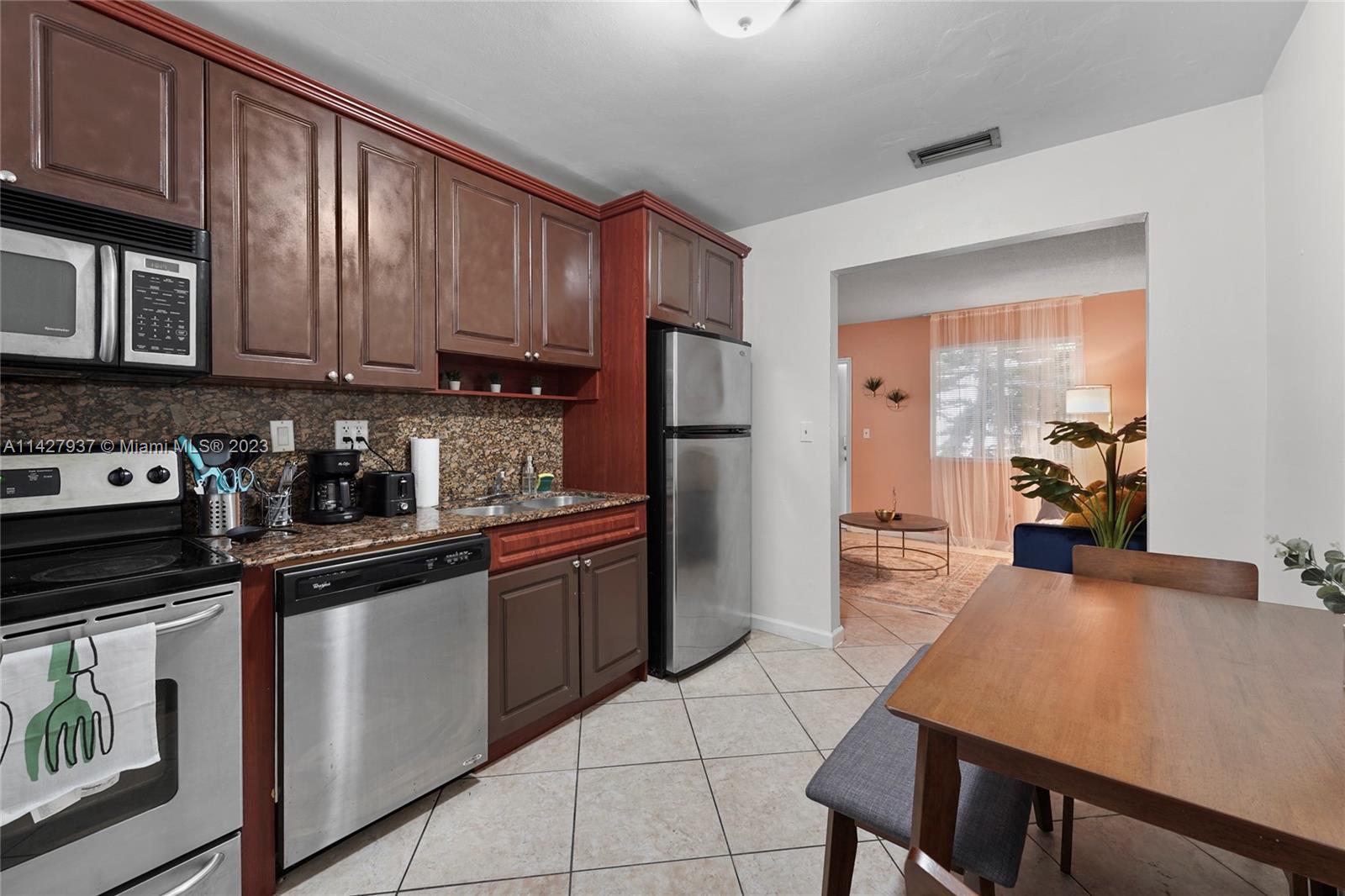 828 Southwest 2nd Street Miami, FL 33130 - Photo 2 of 13 a kitchen with stainless steel appliances granite countertop a stove refrigerator sink and cabinets