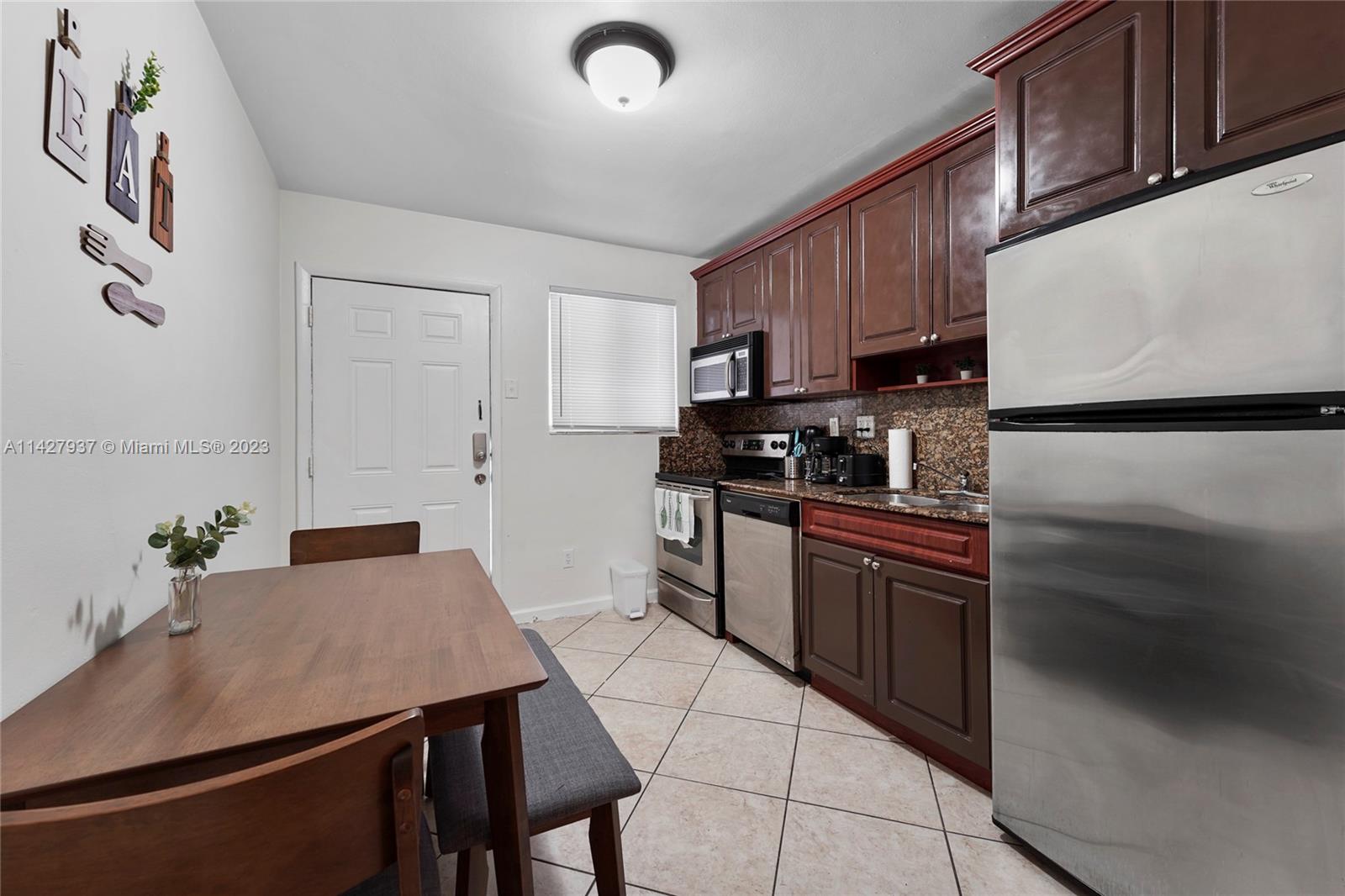 828 Southwest 2nd Street Miami, FL 33130 - Photo 3 of 13 a kitchen with kitchen island granite countertop a sink cabinets and stainless steel appliances