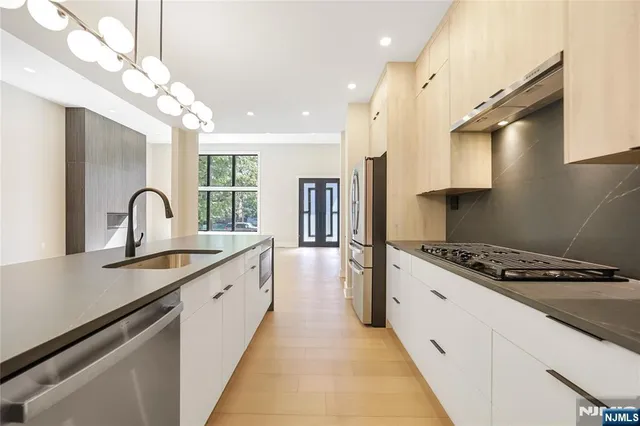 a kitchen with granite countertop a stove a sink a refrigerator and window