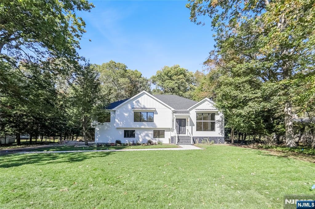 314 Meadowbrook Road Wyckoff, NJ 07481 - Photo 3 of 22 a front view of a house with a garden and trees