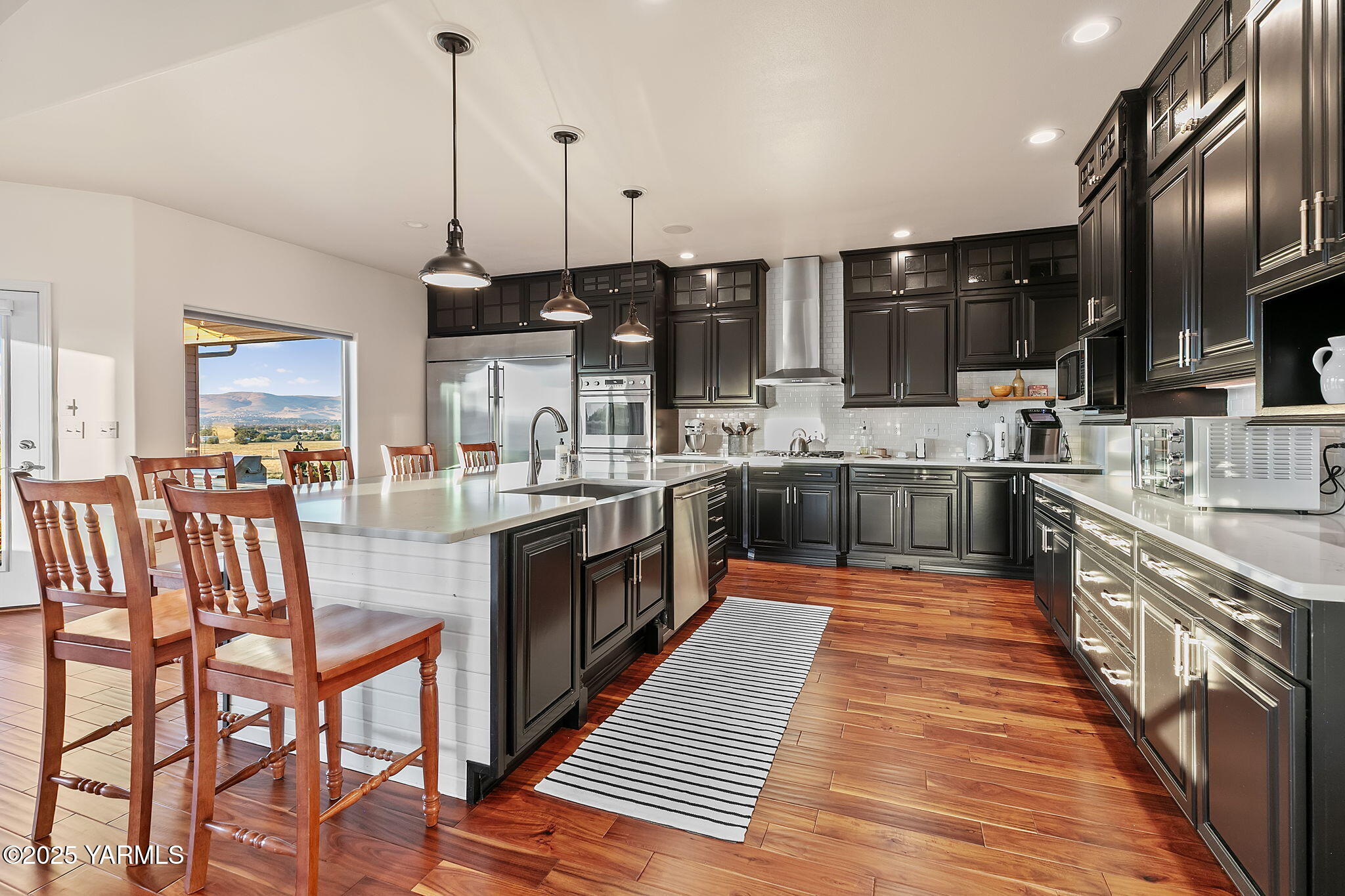 a large kitchen with stainless steel appliances kitchen island granite countertop a large stove a sink a dining table and chairs