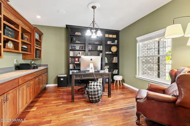 a dining room with wooden floor a chandelier a wooden table and chairs