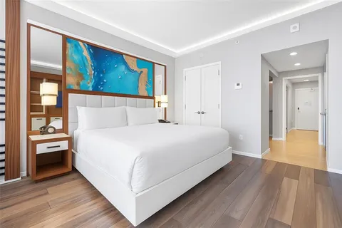 a bedroom with a large bed and a painting on the wall