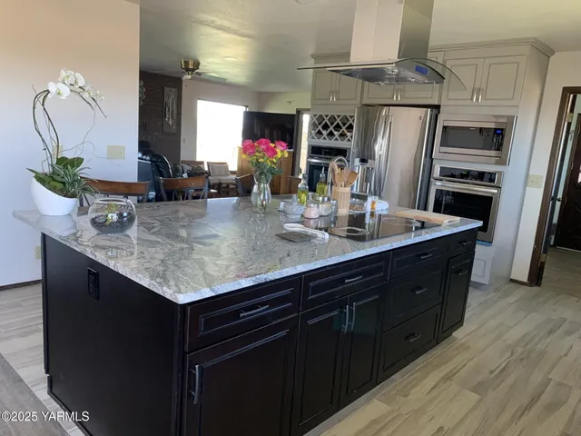 a kitchen with stainless steel appliances granite countertop a sink refrigerator and microwave