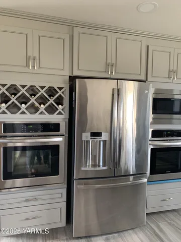 a kitchen with granite countertop white cabinets and stainless steel appliances