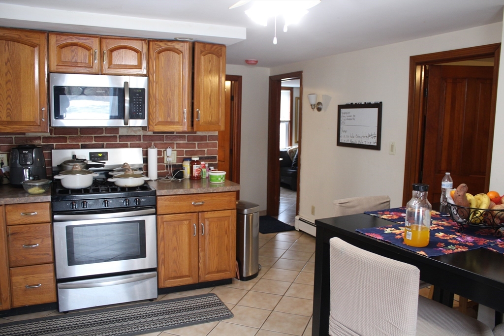 52 Taylor Street Gloucester, MA 01930 - Photo 11 of 12 a kitchen with stainless steel appliances a stove refrigerator and sink