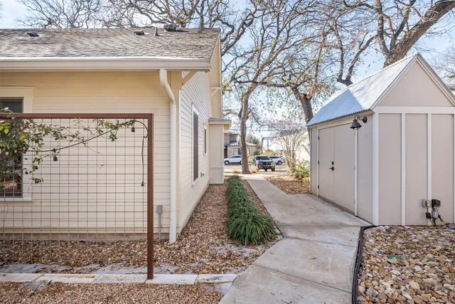 a front view of a house with a yard and large trees