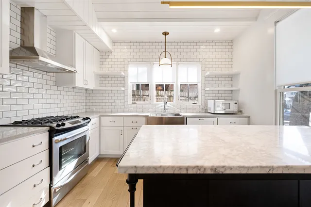 a kitchen with stainless steel appliances granite countertop a sink stove and refrigerator