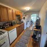 a large kitchen with a stove a sink a refrigerator and wooden cabinets