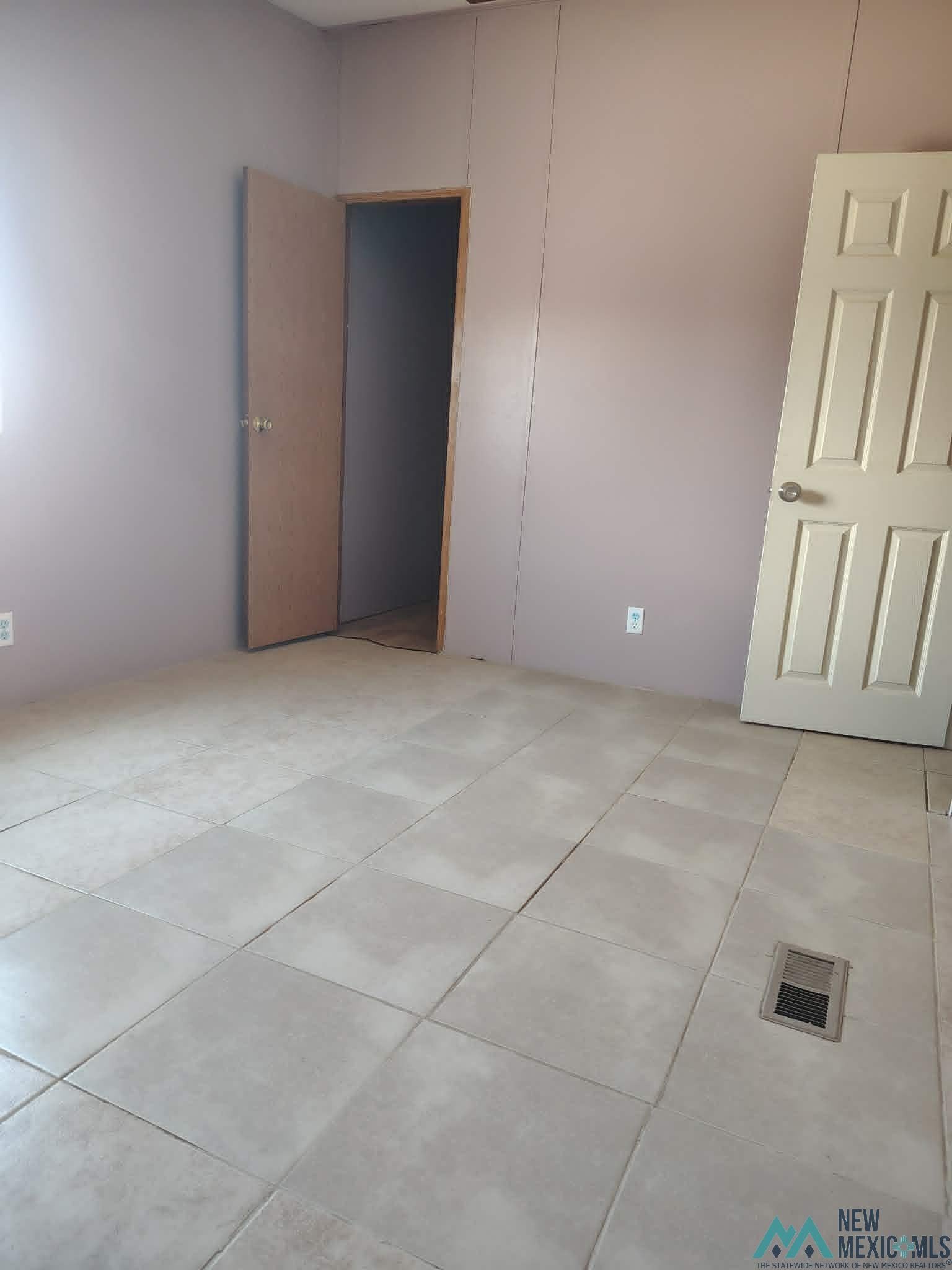 58 Fisk Road Dexter, NM 88230 - Photo 11 of 46 Spacious interior room featuring light-colored square tile flooring, two solid doors, and a floor vent