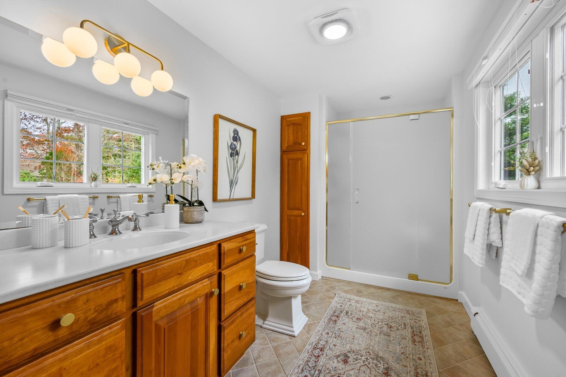 239 Clamshell Cove Road Cotuit, MA 02635 - Photo 18 of 30 a bathroom with a sink a toilet and a large mirror
