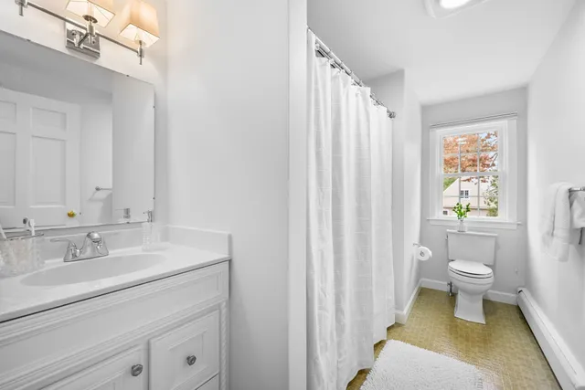 a bathroom with a sink a toilet and shower curtain