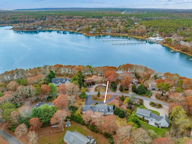 an aerial view of ocean and residential houses with outdoor space