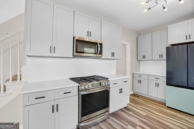 a kitchen with white cabinets and stainless steel appliances
