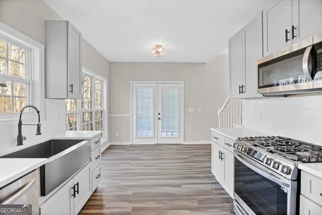 a kitchen with stainless steel appliances a stove a sink and a microwave