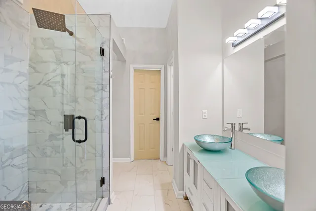 a bathroom with a granite countertop sink a toilet and shower