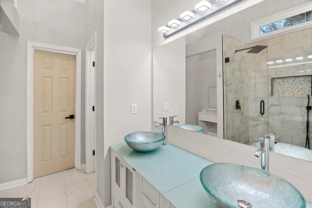 a bathroom with a granite countertop sink a toilet and shower