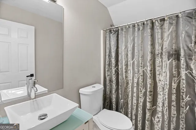 a white toilet sitting next to a bathroom sink