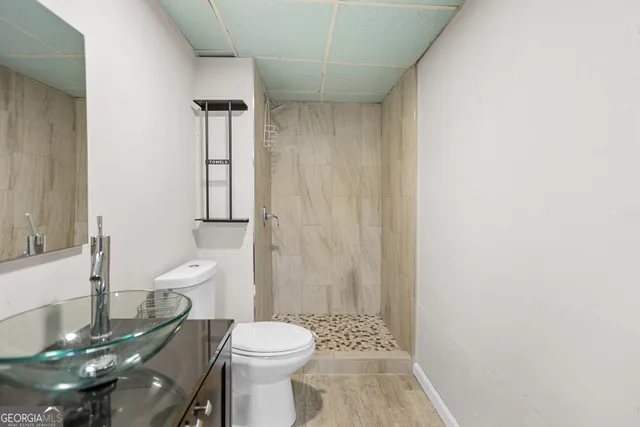 a bathroom with a sink a toilet and shower