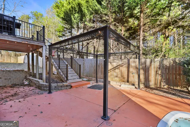 a view of backyard with wooden fence and large trees